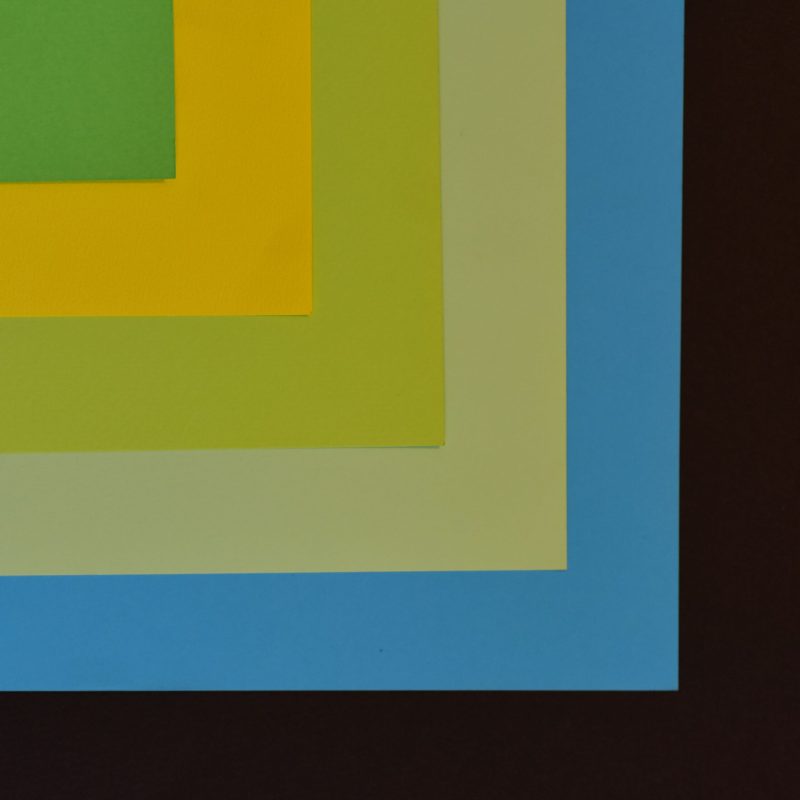 Abstract composition with colorful layered paper creating a geometric pattern.